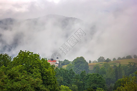 美丽的山地风景 独自在山上建筑和喷雾戏剧性环境爬坡天气场地旅行森林顶峰山脉天空图片