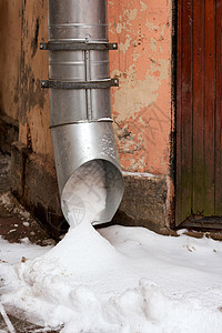 房子拐角处的金属水管充满了积雪建筑冰柱危险街道排水管天气季节城市流动管子图片