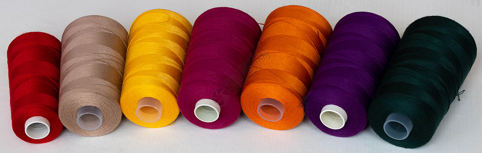 白色背景上孤立的多彩波宾鸟全景筒管纤维蓝色丝绸工艺裁缝紫色纺织品橙子剪裁图片