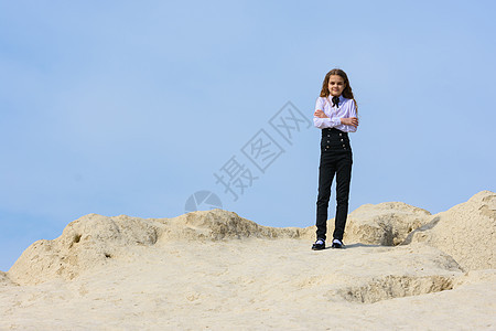 一个穿着白衬衫的姑娘 领领领结在山上站立 在天空之幕下图片