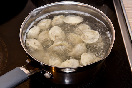 俄国人用沸水中龙卷风煮开的锅里 将猪排在沸水中饺子面团金属午餐美食烹饪厨具食谱饮食厨房图片