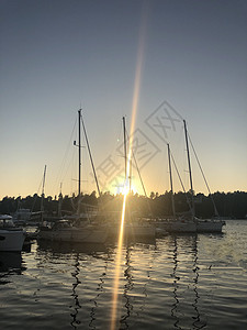 日落前在港口的船射线太阳耀斑太阳光线图片