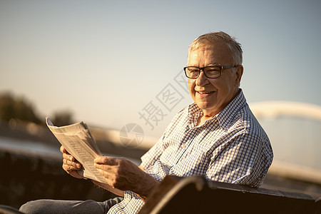 高级男子码头成人文学退休老年报纸快乐微笑男性闲暇图片