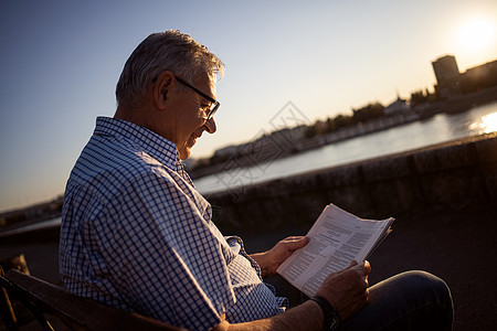 高级男子报纸阅读白发快乐城市晴天成人长椅老年退休图片