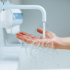 在水龙头下有流水的水龙头打扫清洁温泉喷口液体浴室卫生男人细菌图片
