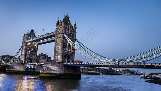 城市在夜幕中沿着著名的塔桥观光 蓝天空和泰晤士河的反射景观历史建筑运输旅游天空工程地标首都旅行图片