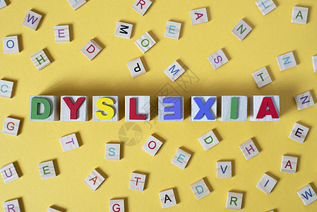 黄色背景中心有 DYSLEXIA 字词的木形字母块图片