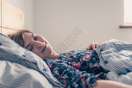 睡觉休息 年轻女性睡在床上 关上门白色午睡毯子闲暇卧室女士说谎时间纺织品就寝图片