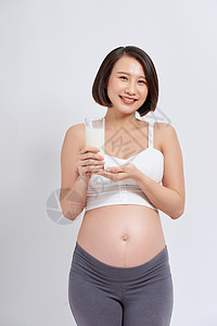 孕妇饮食怀着一杯牛奶的年青年轻孕妇母性营养微笑女性玻璃腹部饮食女士怀孕成人背景