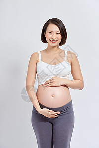 一位美丽的亚洲妇女站着触摸她的肚子 怀孕和期望的概念 笑声生活婴儿腹部产妇女士女性母性孩子窗户母亲图片