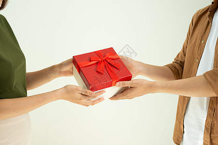 男性向白背景女性提供红色礼物盒的近身男子浪漫男人礼物盒子成人女朋友恋人周年焦点男朋友图片