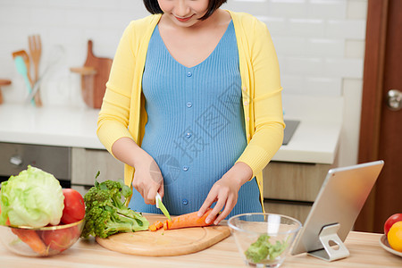 美丽的 笑着微笑的年轻孕妇 在家中厨房准备健康食品和许多水果及蔬菜以配制健康的食品营养生活怀孕女士孩子父母母性家庭沙拉母亲背景图片