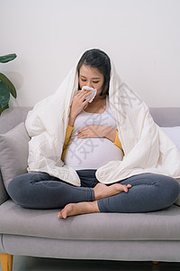 怀孕和寒冷 生病的孕妇 在组织中爆鼻 感觉不舒服坐在家里的小屋流感女性沙发鼻子过敏卫生保健发烧疾病喷嚏图片