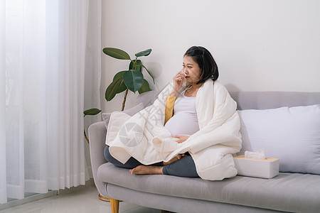 怀孕和寒冷 生病的孕妇 在组织中爆鼻 感觉不舒服坐在家里的小屋感染发烧母亲腹部女性女士流感医疗母性长椅图片