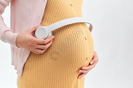肚子上戴耳机的孕妇妈妈沙发成人婴儿腹部母性母亲音乐怀孕女士图片