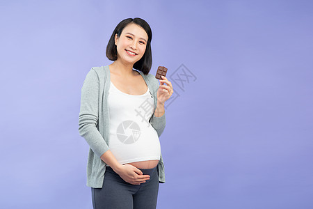 孕妇吃巧克力棒的巧克力女士腹部母亲母性婴儿食物怀孕父母成人图片