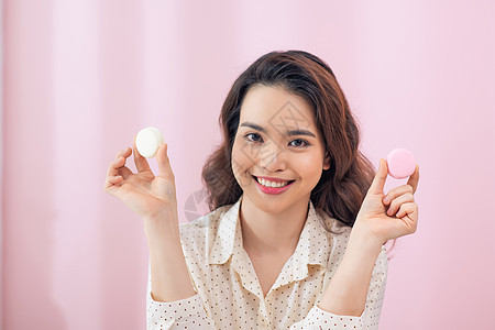 近身的亚洲年轻女人 在粉红背景下吃蛋糕面纱食物女性饼干甜点女孩成人女士图片