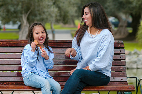 母亲和女儿坐在长凳上 吃饼干吃曲奇饼孩子拥抱家庭童年成人闲暇父母婴儿幸福女性图片
