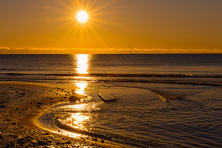 冬季日落支撑海滩旅行海洋橙子波浪天空海岸岩石太阳图片