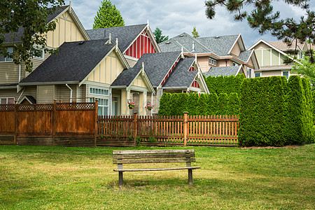 公园中的旧木板凳在民宅前 位于一个公园的老木板凳上图片