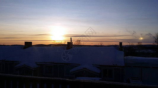 瑞典北部一个小雪小镇日出 位于瑞典北部反射全景风景森林橙子日落阴影建筑农村村庄图片