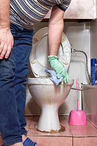 一个人用抹布擦洗脏马桶的边缘 清洗厕所图片