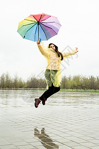 美丽的黑发美女 在雨中拿着多彩的雨伞成人季节女士快乐幸福天气女性乐趣彩虹街道图片