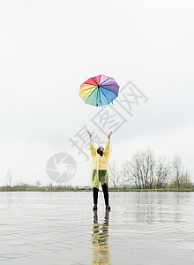 黑褐色女人在雨中扔了彩色伞图片