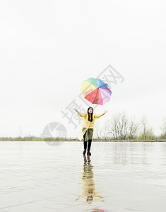 有趣的女人在雨中 在户外捕捉多彩的雨伞女士下雨喜悦街道成人快乐雨衣乐趣幸福城市图片