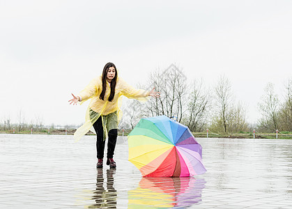 有趣的女人在雨中 在户外捕捉多彩的雨伞彩虹城市天气街道喜悦季节下雨乐趣女士快乐图片