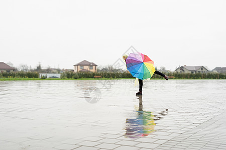 美丽的黑褐色女人 在雨中舞着多彩的雨伞季节微笑下雨女士彩虹快乐喜悦天气城市幸福图片