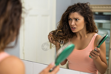 女人已经厌倦了梳她的长头发女士沮丧卷发治疗刺激头发挫折悲伤棕色美容图片