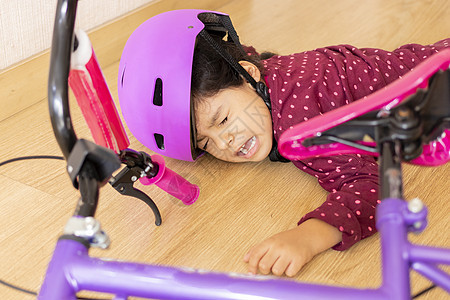 伤心的小女孩在屋里玩自行车时摔倒在地女孩哭泣疼痛运输碰撞弯头情况痛苦悲伤客厅图片