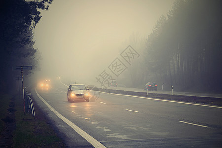 恶劣天气驾驶雾蒙蒙的乡间小路 高速公路道路交通 冬季时间尾巴危险车辆速度头灯旅行司机薄雾下雨状况图片