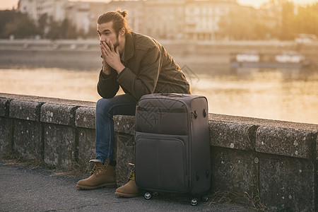 绝望的商务人士与手提箱坐失落城市生活胡须商务男性行李游客旅游日落悲伤经理图片