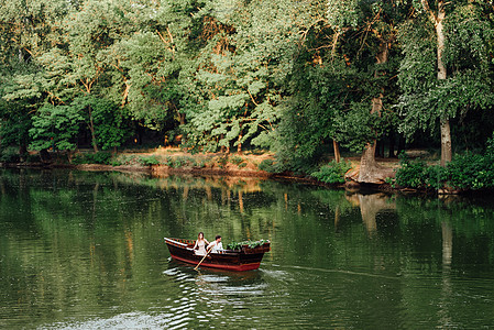 沿河的运河和海湾 为一名男子和一名女孩出海旅行水面棕色支撑男朋友藻类灌木丛恋人青年绿色植物渠道图片