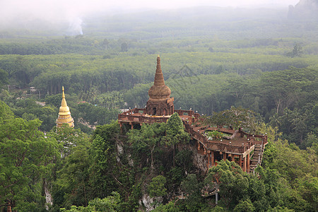 在泰国南部苏拉特萨尼省寺庙 山峰和树上挂着塔塔的美丽日出景观图片