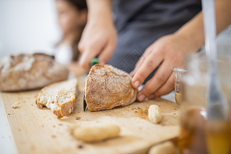 女性用手在切割板上切面包营养木辊小姑娘食物小吃坚果烹饪食谱美食早餐图片