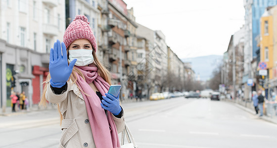 戴冠状面罩的妇女向照相机发出停止信号技术女士危机安全防护服城市社会景观面具口罩图片