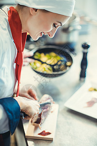 厨师在豪华餐厅煮饭 厨房切火腿做菜商业职业烹饪盘子食物美食男性女士质量白色图片