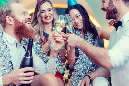 一群朋友在酒吧里喝着香槟和庆祝的烤面包图片