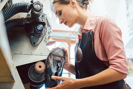 在其制鞋车间中从事机器工作的妇女科布勒女士工匠修理作坊商业店铺围裙维修本生意职业图片
