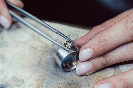 珠宝首饰在戒指上架设一枚宝石制作者工作台手工作坊工作商业工匠金匠男人修理图片