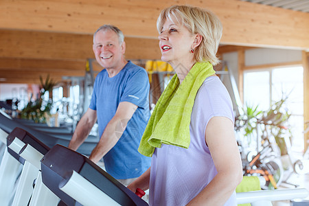 年长夫妇在健身房运动场的跑步机上共同锻炼妻子丈夫健身活动有氧运动老年人俱乐部体操乐趣男人图片