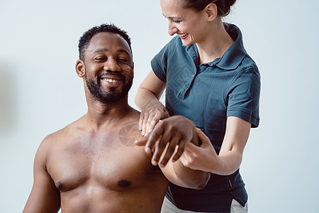 在物理治疗中重新调动肩上联合的肩膀动员治疗整脊病人白色生理学医疗女士治疗师黑色图片