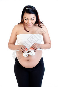 孕妇肚子上戴着一双婴儿鞋的孕妇图片