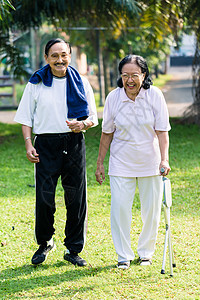 老年夫妇在公园中行走花园脖子福利微笑闲暇妻子太阳镜丈夫阳光成人图片