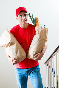 送货员携带两个装有食品的杂货购物袋图片