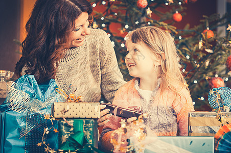 圣诞节的家庭 在树下拆开礼物的圣诞日聚会展示惊喜喜悦孩子父母幸福女孩妈妈小玩意儿图片