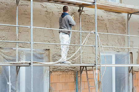 新建房屋外墙贴工石膏的工人劳动工作服建筑工人工匠绝缘泥水匠工作砂浆瓦工水泥背景